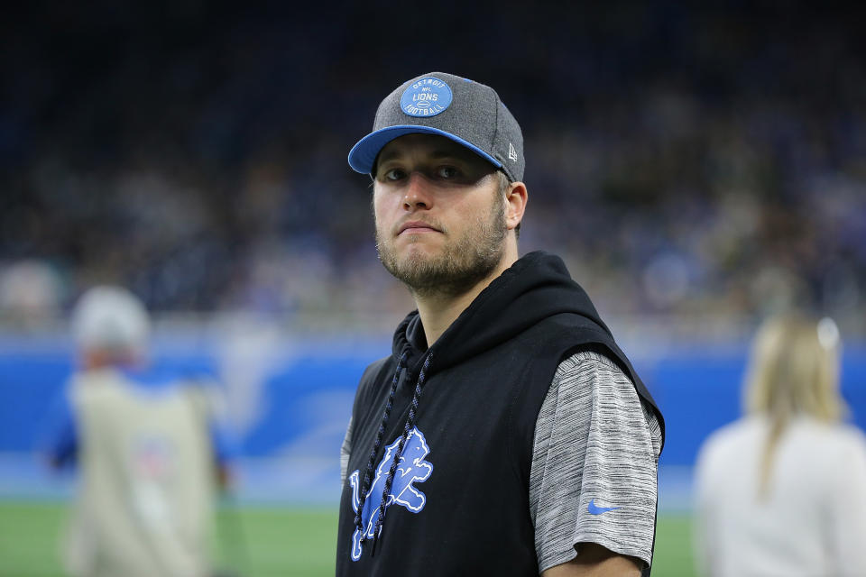 A close-up shot of Matthew Stafford wearing a baseball cap and Lions shirt.