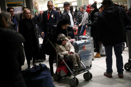 Alma Kashkooli, (12), from Iran who has a severe medical condition sits in a stroller as she is comforted by her mother Farimeh Kashkooli who is living in the United States on a student Visa while studying at Fordham University Law School in New York, inside Terminal 1 upon arrival at New York's John F. Kennedy International Airport in New York after traveling from Istanbul Turkey February 6, 2017. REUTERS/Mike Segar