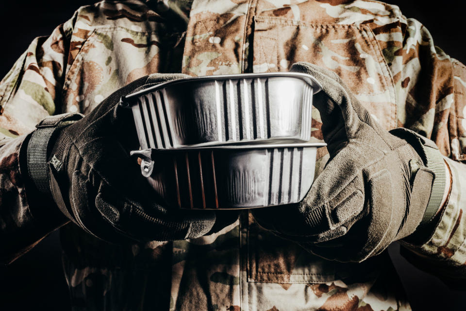 Military worker holding food containers