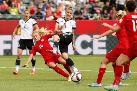 Jul 4, 2015; Edmonton, Alberta, CAN; England defender Alex Greenwood (14) and Germany forward Anja Mittag (11) battle for control of the ball in extra time during the third place match of the FIFA 2015 Women's World Cup at Commonwealth Stadium. Looking on at left is Germany defender Bianca Schmidt (2). England defeated Germany 1-0 in extra time. Erich Schlegel-USA TODAY Sports