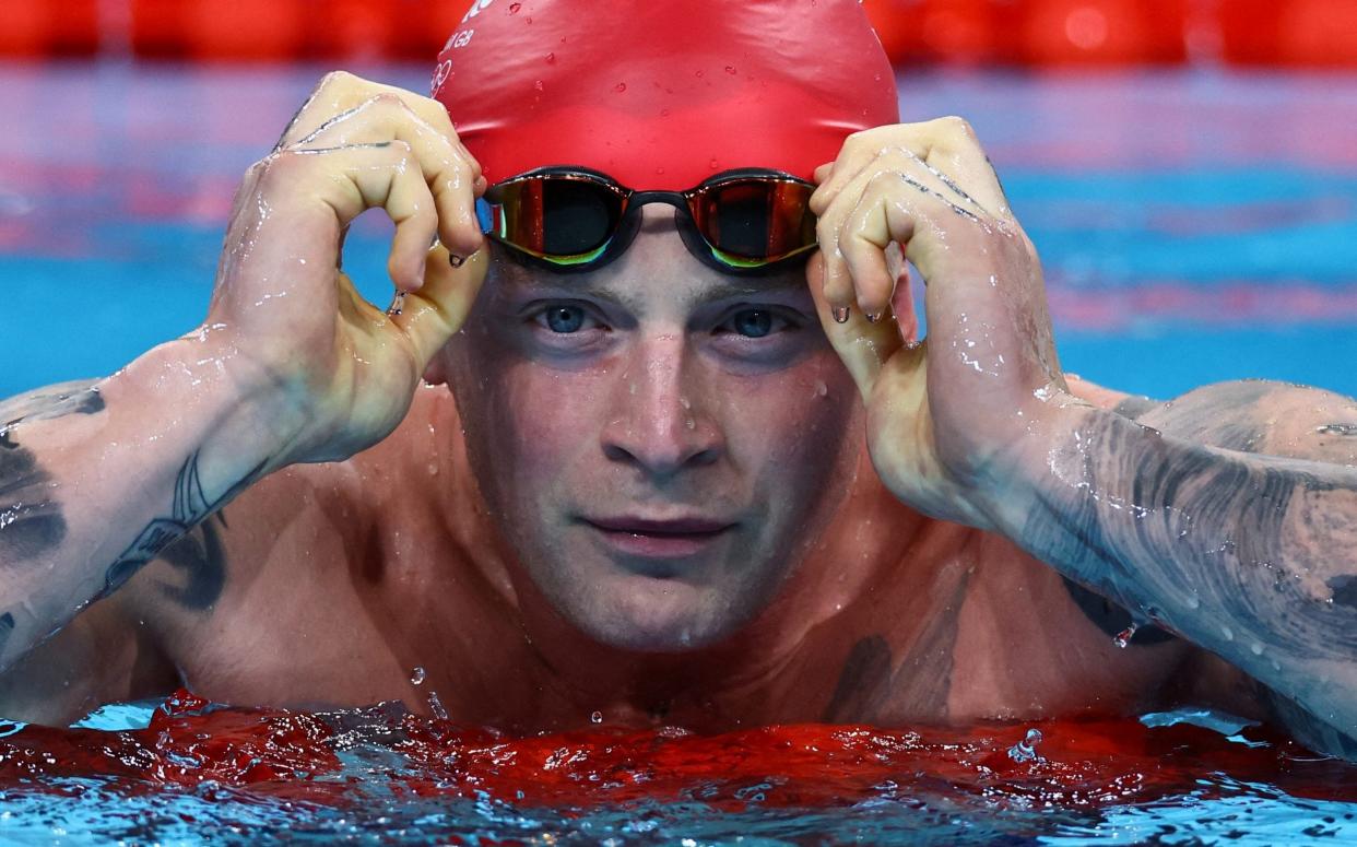 Adam Peaty puts on his goggles before a race