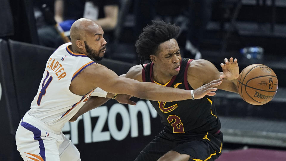 Phoenix Suns' Jevon Carter, left, fouls Cleveland Cavaliers' Collin Sexton in the first half of an NBA basketball game, Tuesday, May 4, 2021, in Cleveland. (AP Photo/Tony Dejak)