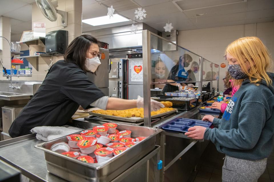 Rachel Wei, a substitute child nutrition team member, serves lunch to Timnath Elementary School students on Tuesday, Jan. 25, 2022, in Timnath.