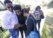 <p>Family members embrace after a student walked out from Marjory Stoneman Douglas High School, Wednesday, Feb. 14, 2018, in Parkland, Fla. The shooting at the South Florida high school sent students rushing into the streets as SWAT team members swarmed in and locked down the building. Police were warning that the shooter was still at large even as ambulances converged on the scene and emergency workers appeared to be treating those possibly wounded. (Photo: Wilfredo Lee/AP) </p>