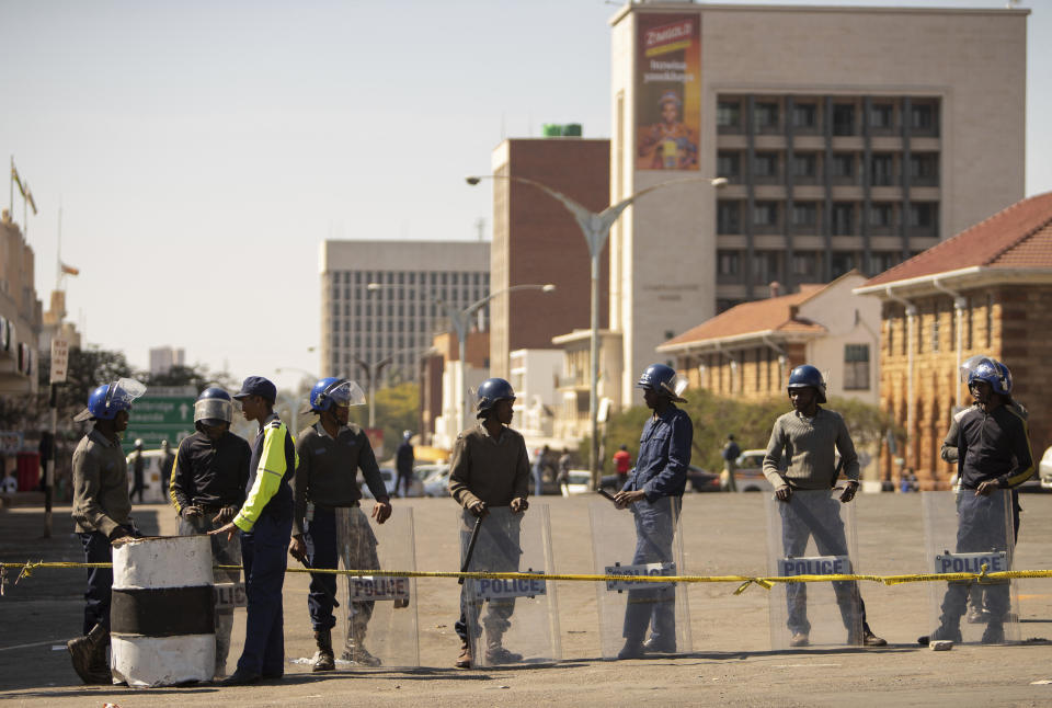 Police man a roadblock in Bulawayo, Zimbabwe, Monday, Aug. 19, 2019. Few people turned up for an opposition protest Monday in the Zimbabwe's second city as armed police maintained a heavy presence on the streets. (AP Photo/Mpofu)