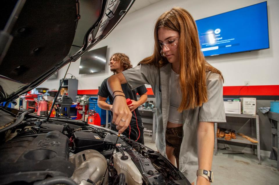 Framingham High School student Kat Barry works under the hood as part of a three-week automotive technology summer boot camp at MassBay Community College's Automotive Technology Center in Ashland, July 27, 2023. While Barry isn't looking for a career in auto technology, she enjoyed learning what she calls "valuable life skills."