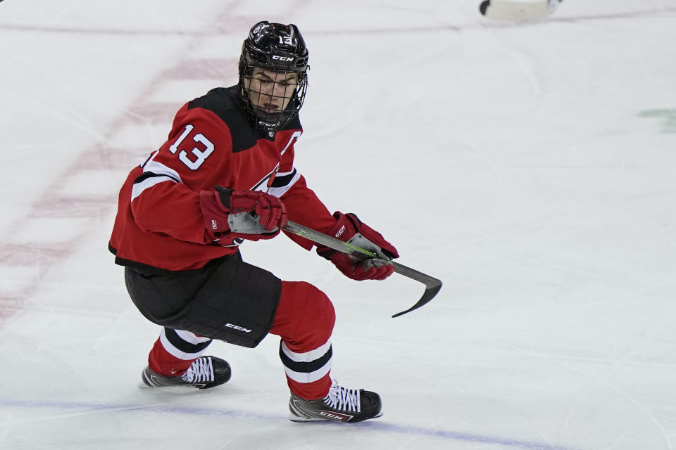 New Jersey Devils center Nico Hischier (13) wears a cage over his face as he returns to the ice after having surgery Feb. 27 to repair a broken nose during the first period of an NHL hockey game against the New York Rangers, Tuesday, April 13, 2021, in Newark, N.J. (AP Photo/Kathy Willens)