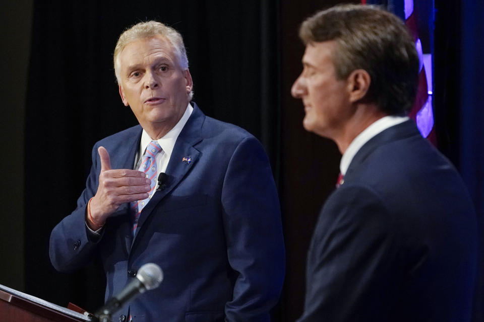 FILE - In this Sept. 16, 2021, file photo Democratic gubernatorial candidate former Governor Terry McAuliffe, left, gestures as Republican challenger, Glenn Youngkin, listens during a debate at the Appalachian School of Law in Grundy, Va. McAuliffe has generally led in public polling, but recent surveys have suggested his lead is tightening. His race against Glenn Youngkin is one of the country’s most competitive and closely watched political matchups of the year. (AP Photo/Steve Helber, File)