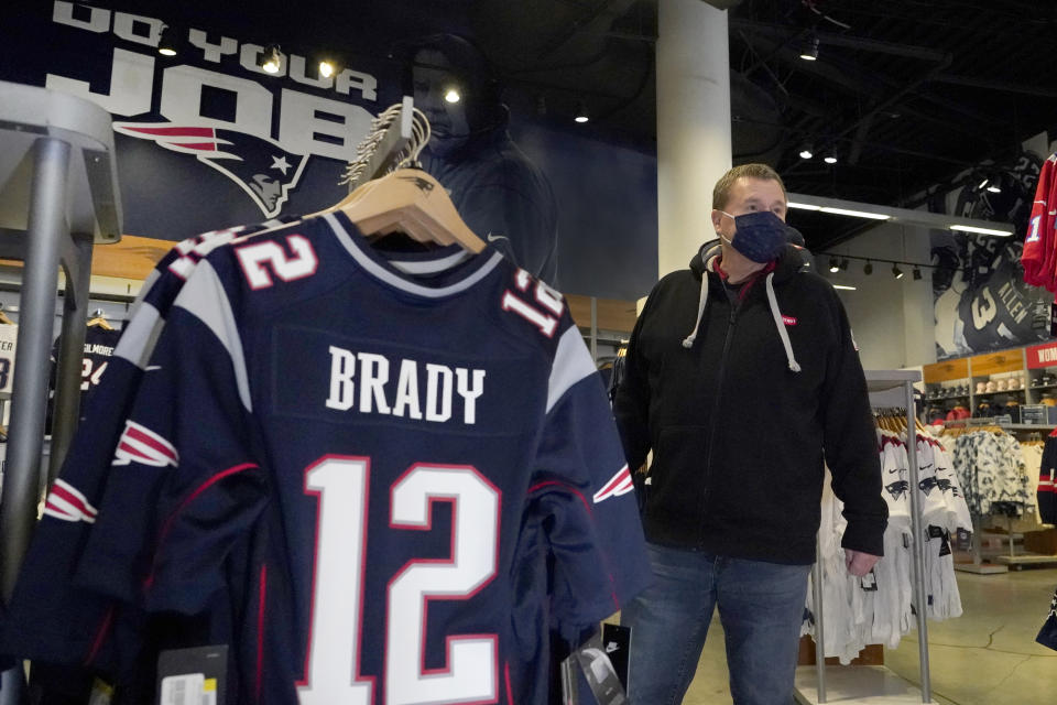 Football fan Brian Pope browses for Tom Brady jerseys in the pro shop at Gillette Stadium, Monday, Jan. 25, 2021, in Foxborough, Mass. Tom Brady is going to the Super Bowl for the 10th time, and New England Patriots football fans are cheering for him -- just like before. (AP Photo/Elise Amendola)