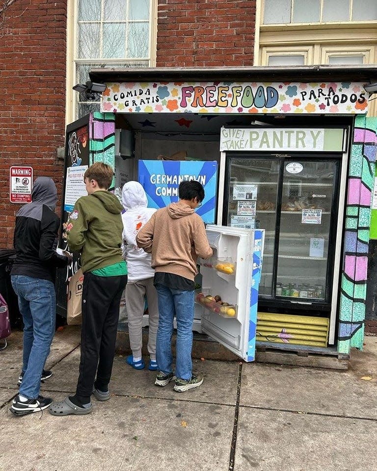 Students fill a community fridge in the Germantown neighborhood in Philadelphia.