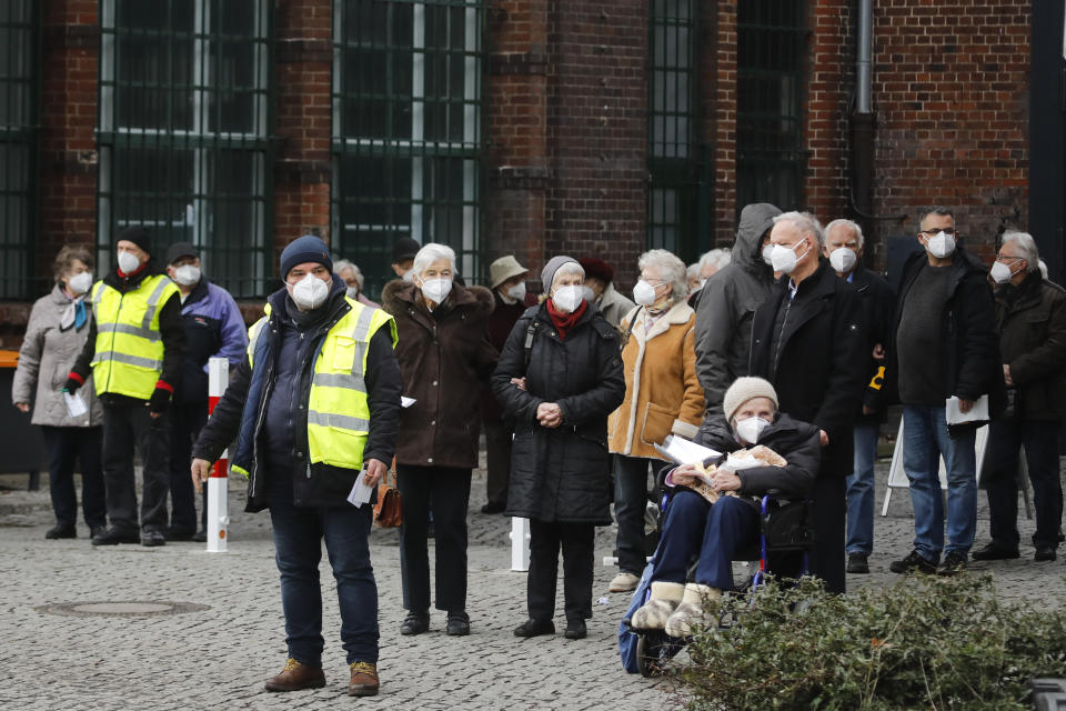 People wait for transportation as they leave the vaccination center against the COVID-19 disease in the district Treptow in Berlin, Germany, Thursday, Jan. 28, 2021. (AP Photo/Markus Schreiber)