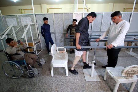 A disabled man tries to walk with his prosthetic leg at the Artificial Limb Centre in Basra, Iraq February 28, 2018. REUTERS/Essam Al-Sudani