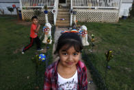 Dulce, de 6 años, y su hermano juegan en el jardín de su casa, situada junto a unas vías en Burlington, Carolina del Norte, el lunes 9 de marzo de 2020. (AP Foto/Jacquelyn Martin)