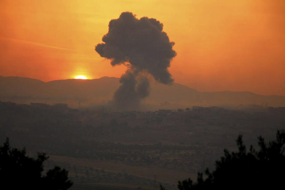 This photo provided Tuesday, May 21, 2019 by the Syrian Civil Defense group known as the White Helmets, shows smoke rising after Syrian government forces targeted the town of al-Habeet, in Idlib province, Syria. Syrian activists and a rebel spokesman said Wednesday, May 22, 2019 that opposition fighters have recaptured Kfar Nabuda, a village at the edge of the last rebel stronghold in northwestern Syria. (Syrian Civil Defense White Helmets via AP)