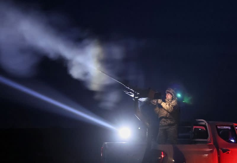 A Ukrainian serviceman from anti-drone mobile air defence unit fires a Browning machine gun at his position during combat in Chernihiv region