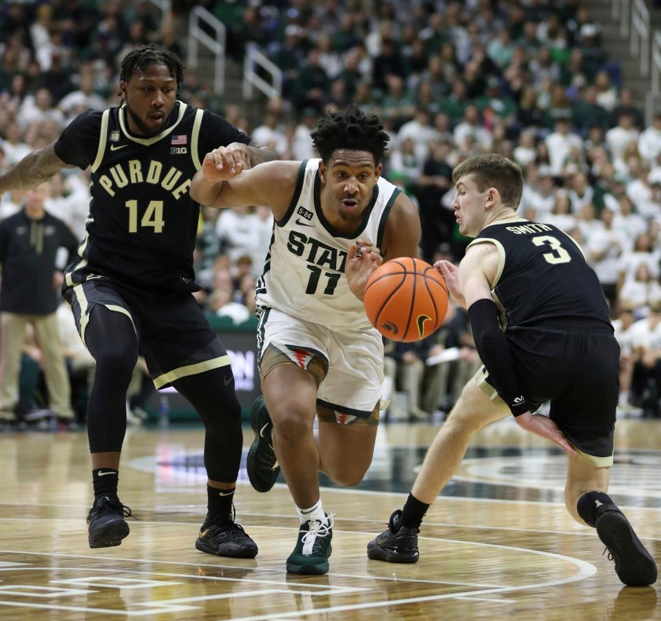 Michigan State Spartans guard A.J. Hoggard drives against Purdue Boilermakers guards David Jenkins Jr. (14) and Braden Smith (3) during the second half Monday, Jan. 16, 2023 at Breslin Center in East Lansing.