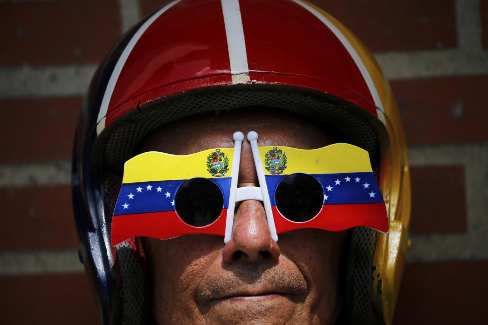 An anti-government protester wears Venezuelan flag motif sunglasses during a demonstration demanding the resignation of President Nicolas Maduro, in Caracas, Venezuela, Saturday, Feb. 2, 2019. Momentum is growing for Venezuela's opposition movement led by self-declared interim president Juan Guaido, who has called supporters back into the streets for nationwide protests Saturday, escalating pressure on Maduro to step down. (AP Photo/Fernando Llano)