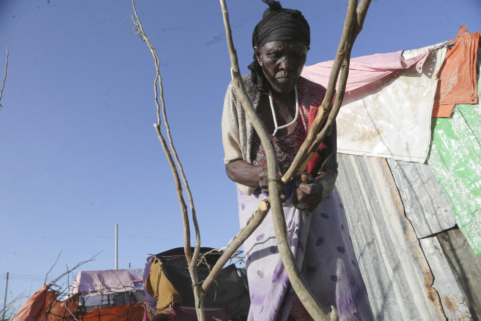 A woman builds her makeshift shelter in Daynile camp in Mogadishu, Somalia on Thursday Dec. 17, 2020. As richer countries race to distribute COVID-19 vaccines, Somalia remains the rare place where much of the population hasn't taken the coronavirus seriously. Some fear that’s proven to be deadlier than anyone knows. (AP Photo/Farah Abdi Warsameh)