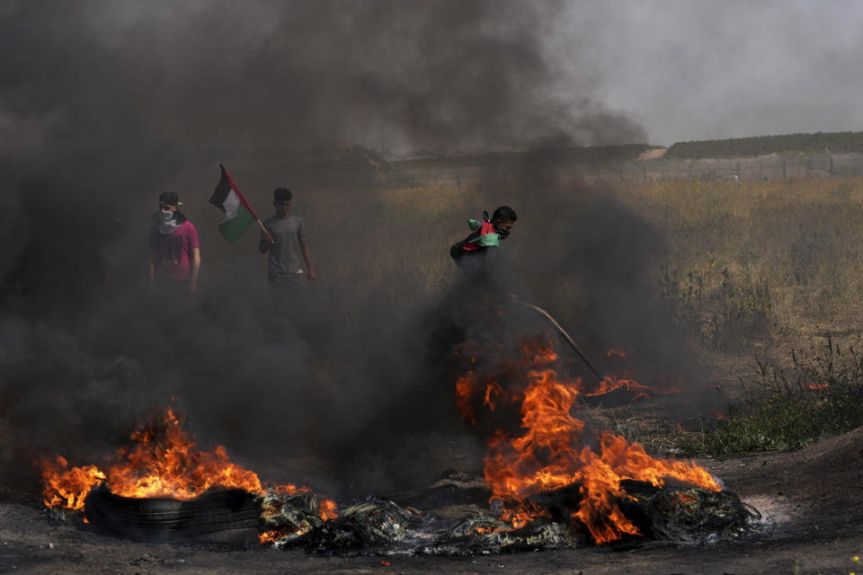 Palestinians burn tires during a protest against an Israeli police raid of the Al-Aqsa Mosque compound in Jerusalem's Old City early Wednesday, along the border fence with Israel, east of Gaza City, Wednesday, April 5, 2023. (AP Photo/Adel Hana)