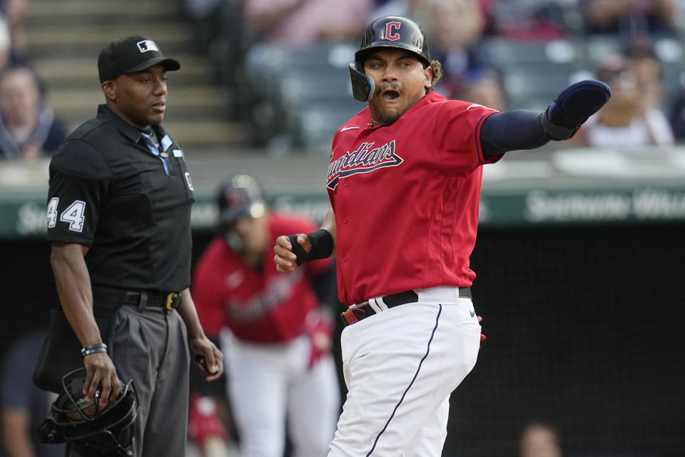Cleveland Guardians' Josh Naylor, gestures as he scores in front of home plate umpire umpire Kerwin Danley (44) during the second inning of the team's baseball game against the Boston Red Sox on Wednesday, June 7, 2023, in Cleveland. (AP Photo/Sue Ogrocki)