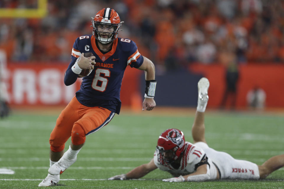 Syracuse quarterback Garrett Shrader (6) evades a tackle by North Carolina State linebacker Payton Wilson (11) during the second half of an NCAA college football game Saturday, Oct. 15, 2022, in Syracuse, N.Y. (AP Photo/Joshua Bessex)