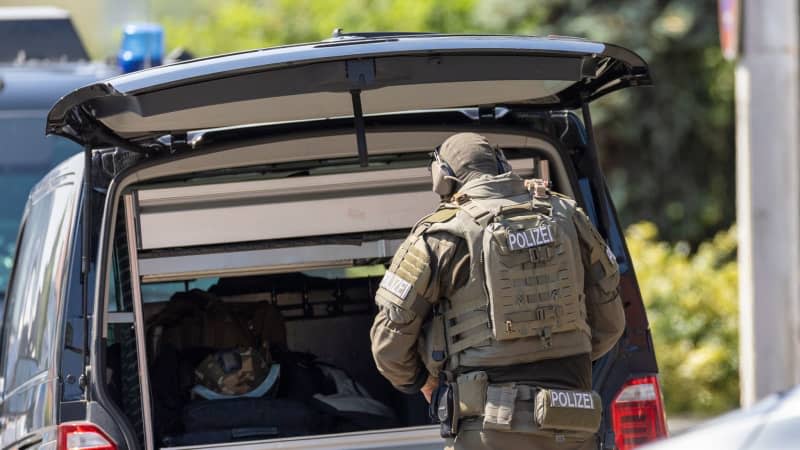 An SEK officer prepares for his mission at an asylum shelter.  A special police task force has provisionally arrested three people.  Heiko Becker/dpa