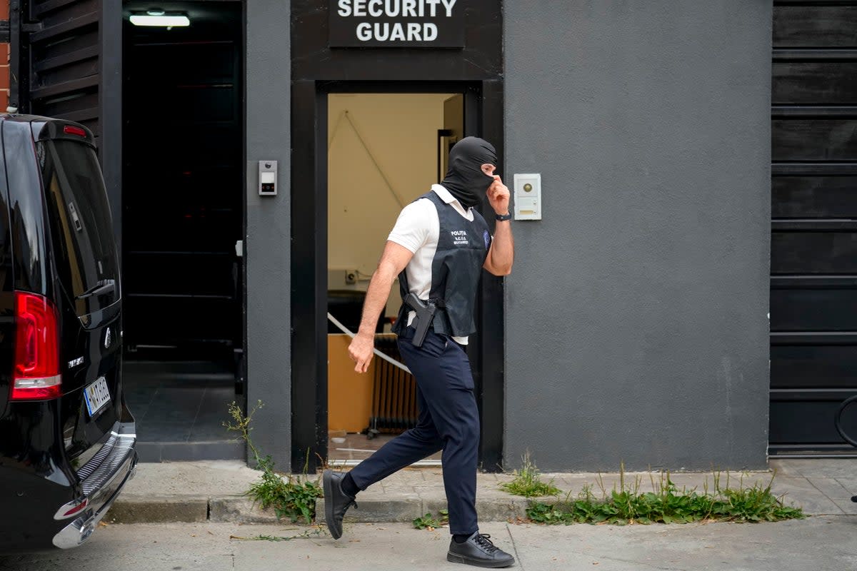 A police officer exits the residence of social media personality Andrew Tate during an early morning search raid, on the outskirts of Bucharest (AP)