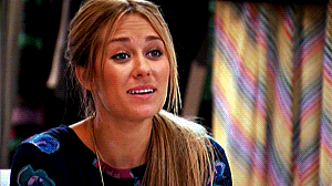 Lauren Conrad putting her hands beneath her chin, as if saying "awee"