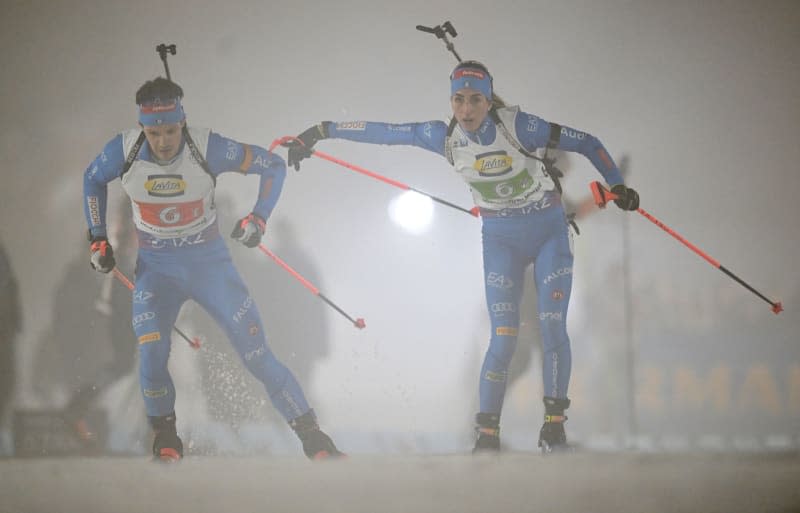 Italian biathletes Tommaso Giacomel (L) and Lisa Vittozzi in action during the mixed individual relay of the Biathlon World Championships.f Hendrik Schmidt/dpa