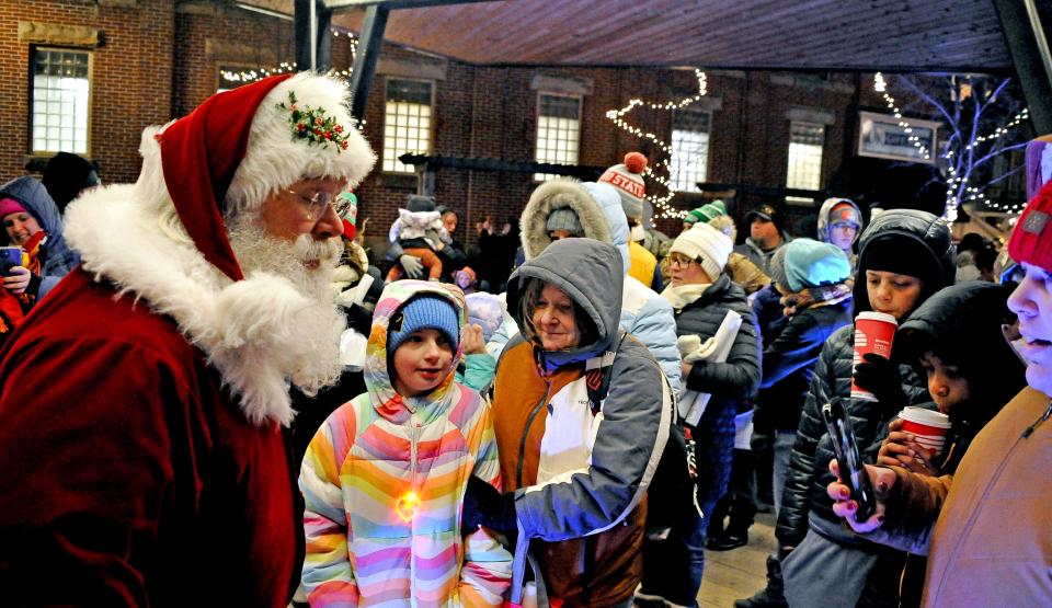 Children crowd around Santa in downtown Wooster on Friday, eager to tell the jolly old elf what they want for Christmas.