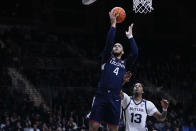 Connecticut guard Tyrese Martin (4) shoots in front of Butler guard Jayden Taylor (13) in the second half of an NCAA college basketball game in Indianapolis, Thursday, Jan. 20, 2022. (AP Photo/AJ Mast)