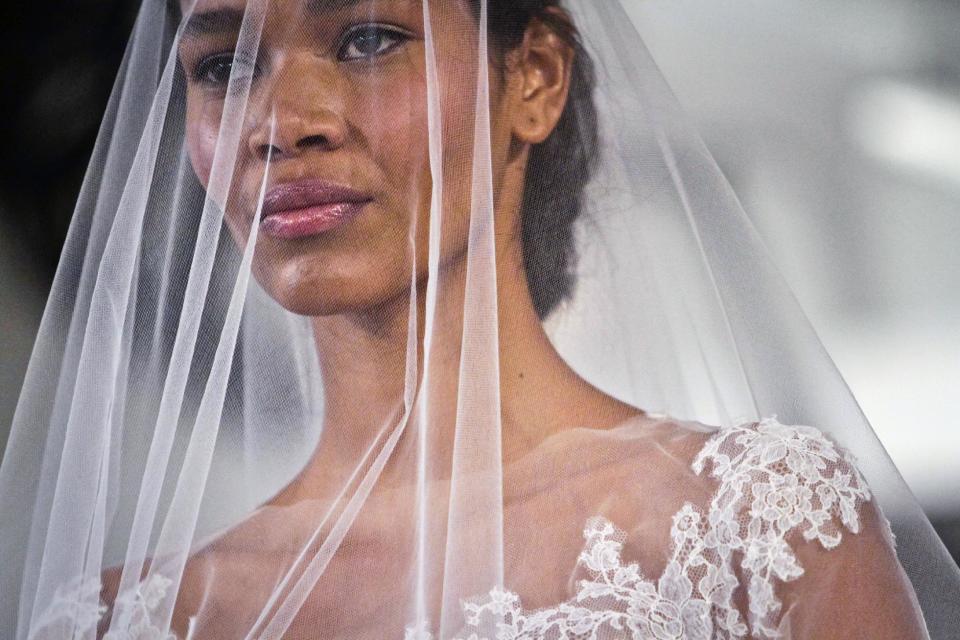 A model presents a bridal fashion creation from the Oscar de la Renta collection, in New York, Monday, April 22, 2013. (AP Photo/Bebeto Matthews)