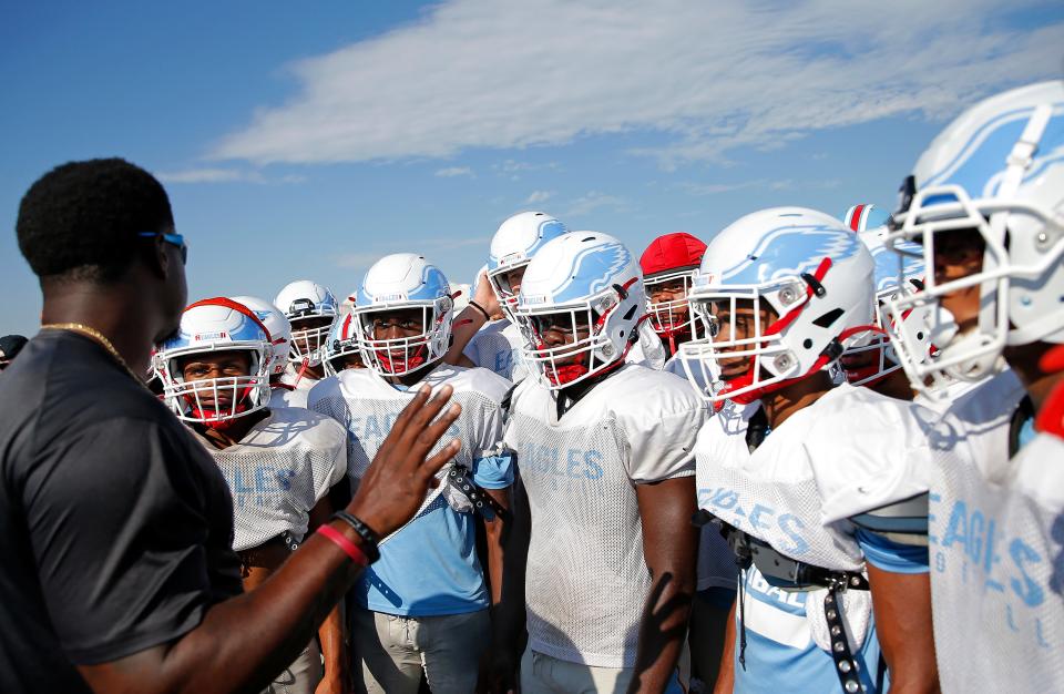 Lawton Eisenhower football coach Javon Harris talks to the team during practice Tuesday.