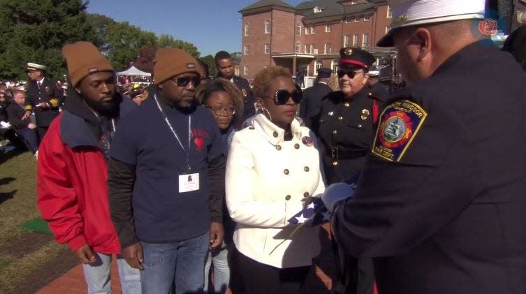 Jacksonville Fire and Rescue Department Engineer Michael Freeland's family accepts a folded American flag during weekend National Fallen Firefighters Memorial events in Maryland.