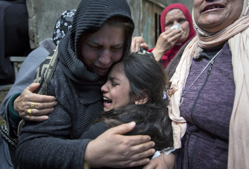 Samira Edwan, 40, left, mother, and Yusra, 10, sister, cry during a farewell look at the body of Mohammad Edwan, 23, who was shot and killed by Israeli troops, in the West Bank Refugee camp of Qalandia, near Ramallah, Tuesday, April 2, 2019. A West Bank medical official said Palestinian Mohammad Edwan was killed in clashes with Israeli forces during arrest raids north of Jerusalem. (AP Photo/Nasser Nasser)