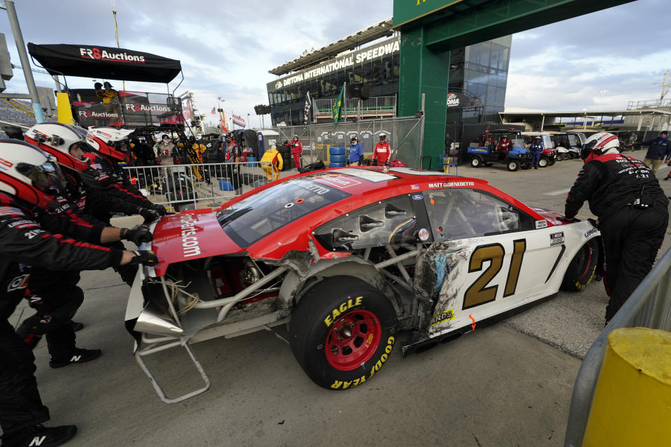 Matt DiBenedetto crew pushes his car to the garage after he was involved in a crash in the NASCAR Cup Series road course auto race at Daytona International Speedway, Sunday, Feb. 21, 2021, in Daytona Beach, Fla. (AP Photo/John Raoux)