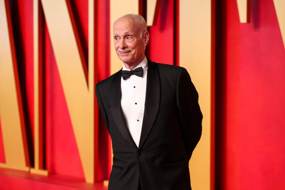 Man in a black tuxedo with a bow tie standing confidently on the red carpet