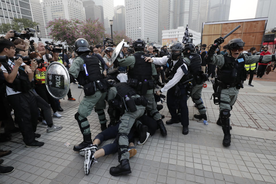 Riot policemen arrest protesters during a rally to show support for Uighurs and their fight for human rights in Hong Kong, Sunday, Dec. 22, 2019. (AP Photo/Lee Jin-man)