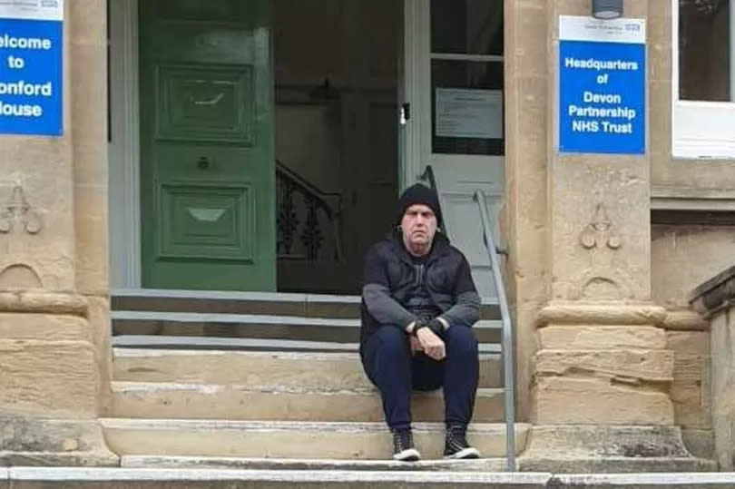 Sean May sat on the steps of Wonford House, the headquarters of Devon Partnership Trust in Exeter