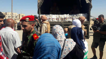 Syrian people are seen as they receive aid from Russian forces in Deir al Zor, Syria in this handout picture provided by SANA on September 10, 2017, Syria. SANA/Handout via REUTERS