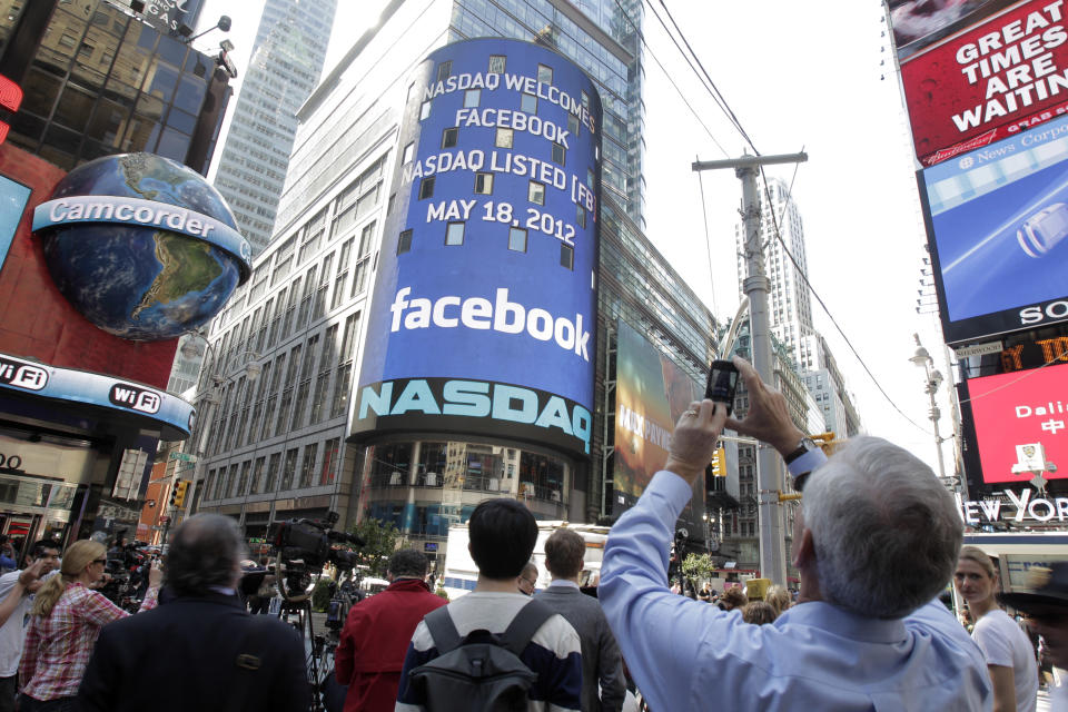 A man stops to photograph Nasdaq in Times Square as Facebook has its IPO, Friday, May 18, 2012, in New York. The social media company priced its IPO on Thursday at $38 per share, and beginning Friday regular investors will have a chance to buy shares. (AP Photo/Richard Drew)