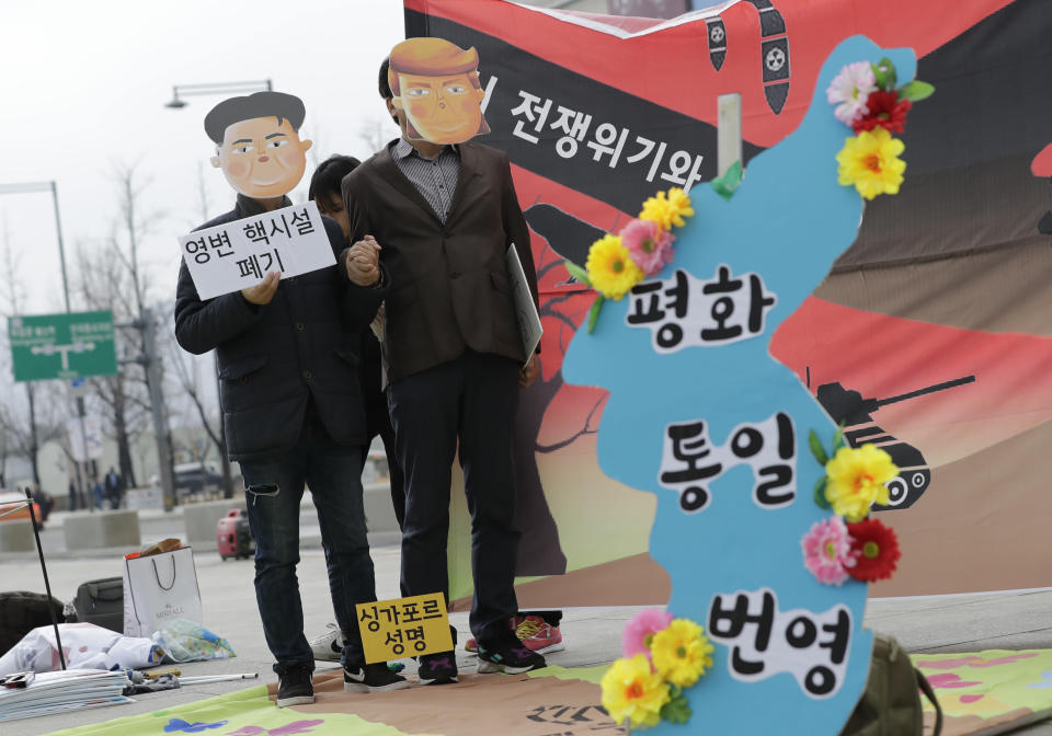 <p> Protesters wearing masks of U.S. President Donald Trump and North Korean leader Kim Jong Un stand near the map of Korean Peninsula during a rally demanding the denuclearization of the Korean Peninsula and peace treaty near the U.S. embassy in Seoul, South Korea, Thursday, March 21, 2019. The Korean Peninsula remains in a technical state of war because the 1950-53 Korean War ended with an armistice, not a peace treaty. More than 20 protesters participated at a rally and also demanding the end the Korean War and to stop the sanction on North Korea. The letters read "Peace and Unification." (AP Photo/Lee Jin-man) </p>