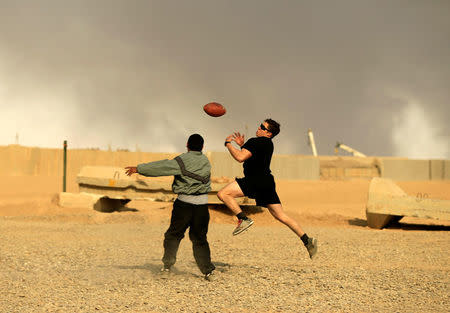 U.S. soldiers play a game of football on Thanksgiving Day inside the U.S. army base in Qayyara, south of Mosul, Iraq November 24, 2016. REUTERS/Thaier Al-Sudani