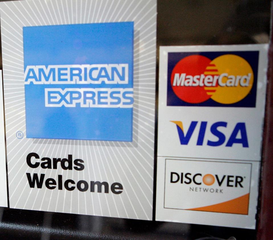 This July 30, 2008, file photo, shows credit card stickers  posted at a bowling alley in Palo Alto, Calif.   Credit-card companies are rushing to raise rates and tack on extra fees ahead of a law slated to take effect Feb. 22 that is supposed to limit such moves in the future. In some cases, rates are doubling to as high as 30 percent or more, even for people who pay their bills on time. 