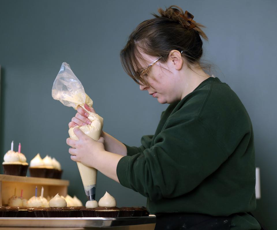 Michela Rocco, owner of Rocco's Cupcake Cafe, frosts her Monkey Business cupcakes, Tuesday, Feb. 7, 2023, in Kent, Ohio.