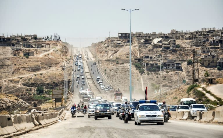 Cars and military vehicles drive along the main highway between Homs and Hama in central Syria