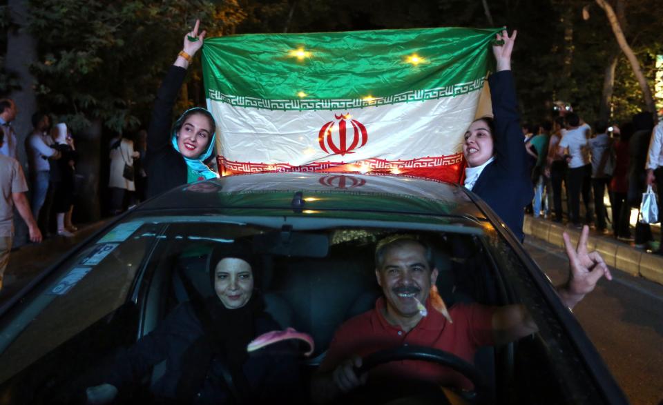 Iranian women wave the national flag during celebration in northern Tehran on July 14, 2015, after Iran's nuclear negotiating team struck a deal with world powers in Vienna.