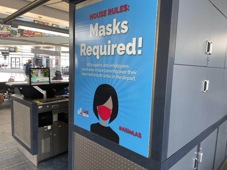 Posters at McCarran Airport in Las Vegas last Friday informed passengers that masks should be worn. (STAR MAX/IPx via AP)