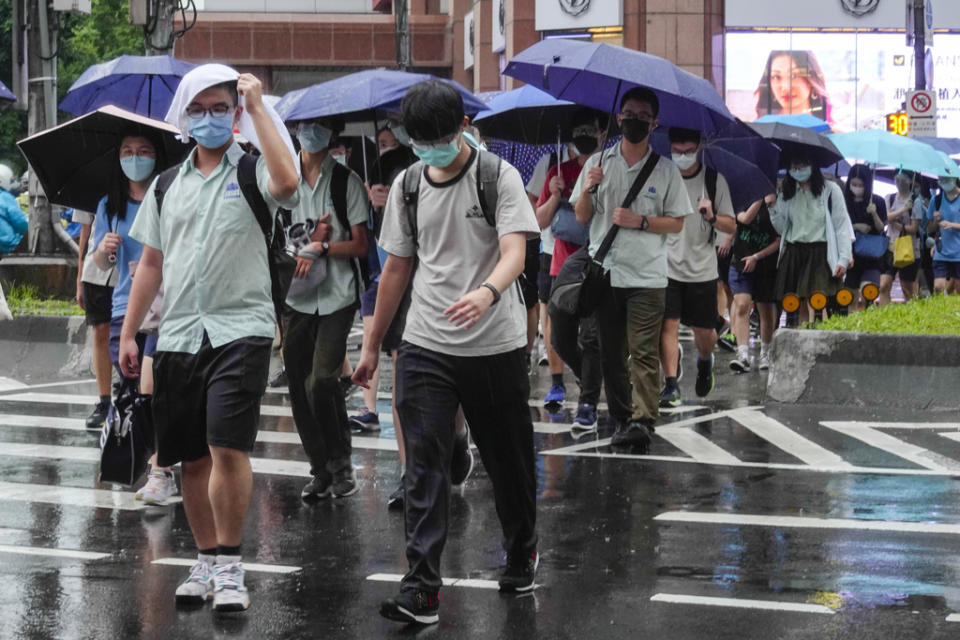 台北市中小學6日恢復實體課，大批學生下午放學後撐傘經過東區一處路口。（黃子明攝）