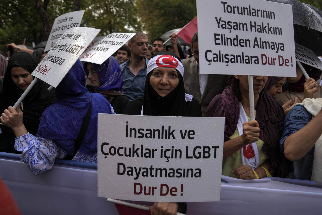 Turkish demonstrators chant slogans while holding banners that read, " Say no to the imposition of LGBT for humanity and children", " Say stop to those who try to take away their grandchildren's right to life" during a anti LGBTI+ protest, in Fatih district of Istanbul, Sunday, Sept. 18, 2022. (AP Photo/Khalil Hamra)